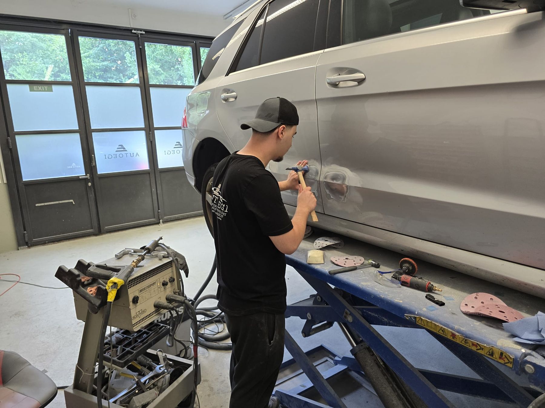 Ausbeularbeit an einer Mercedes-Benz-Tür in der Werkstatt von AUTOEGI